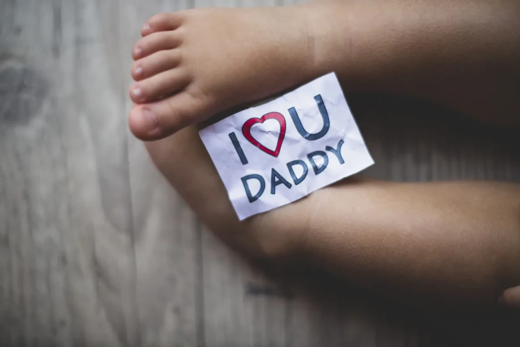 Pieds de bébé avec un message “I love you daddy” posé dessus pour célébrer le lien père-enfant