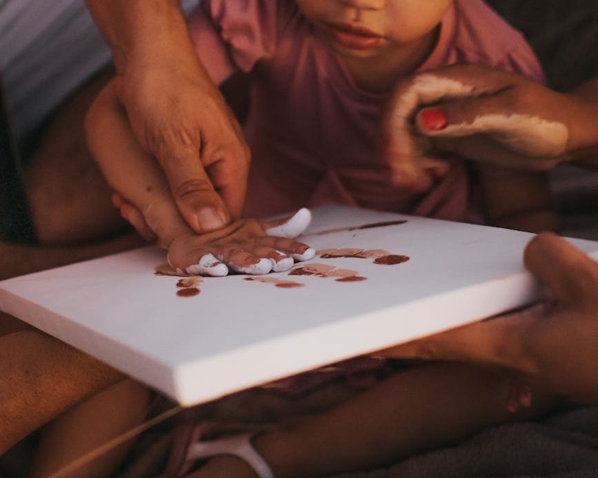 parents helping daughter with painting